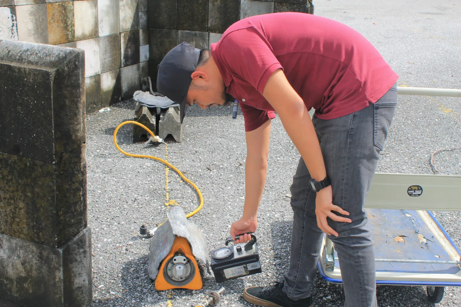 RadSentric technician reading a survey meter next to an orange Iridium-192 gamma projector during a field exercise