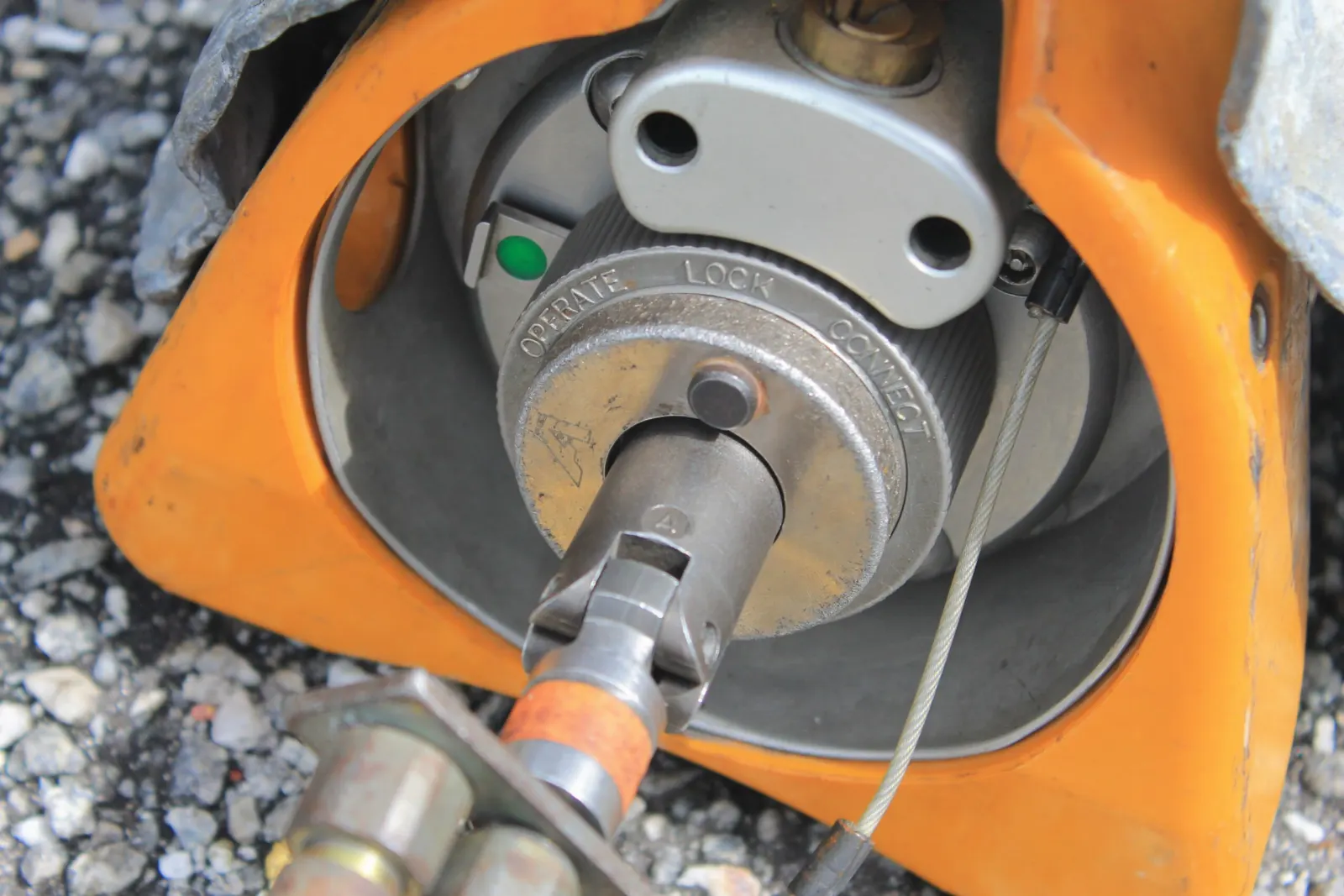 Close-up of the winding cable connection on an orange Iridium-192 gamma projector with its Operate, Lock and Connect ring